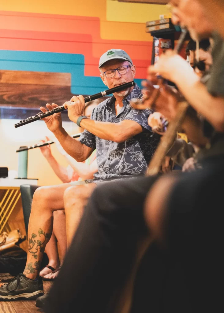 Man playing the Irish flute in a traditional Irish music session.